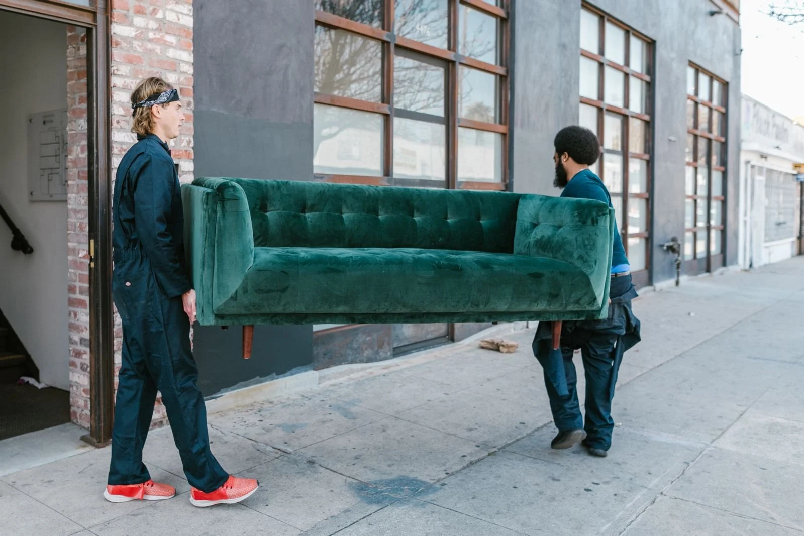 Team carrying a sofa out of a property